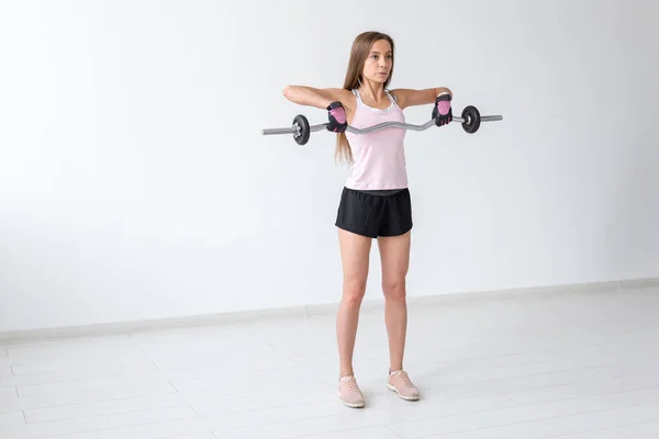 Sport, fitness a lidé koncept - krásná mladá žena dělá cvičení s činka — Stock fotografie