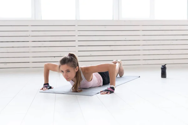 Estilo de vida saudável, esporte, conceito de pessoas uma jovem está fazendo fitness no ginásio ou em casa. Ela está pressionando no terno esporte — Fotografia de Stock