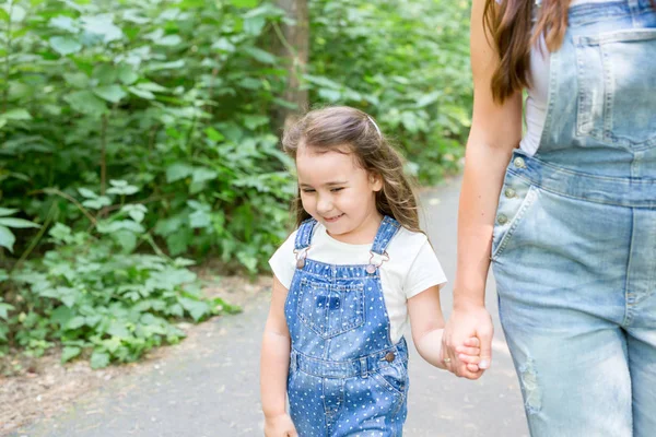 Concepto de familia, naturaleza y personas: mamá e hija pasan tiempo juntas en un paseo por el parque verde —  Fotos de Stock