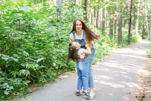 Родина, природа, концепція людей - мати і дочка обіймаються в парку — стокове фото