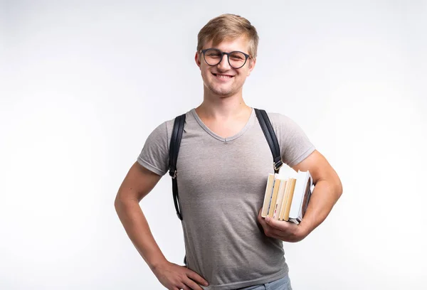 Reading, education, people concept - a young student man holding many books — Stock Photo, Image