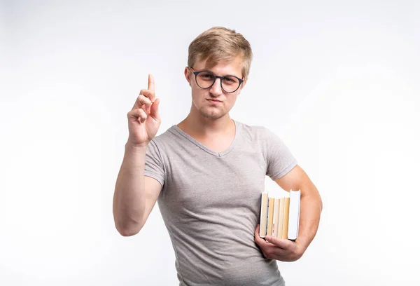 Persone, conoscenza ed educazione - Ritratto di uno studente vestito con una t-shirt grigia che tiene in mano dei libri — Foto Stock