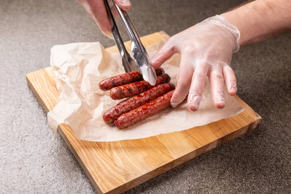 Еда, вкусная и обслуживающая концепция - жареные колбасы на деревянной доске — стоковое фото