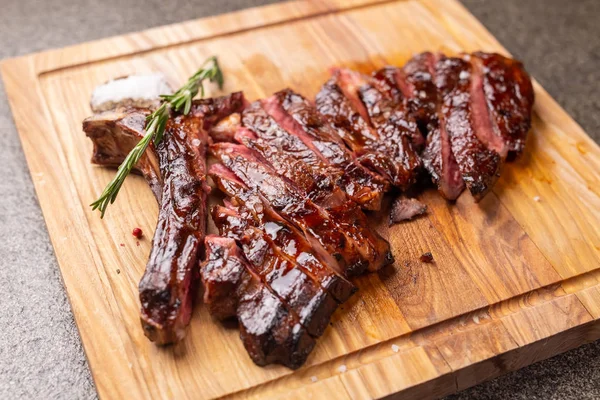 Konsept for kjøtt og hestekjøtt - Stekt kjøtt på nedskjæringstavle med karve – stockfoto
