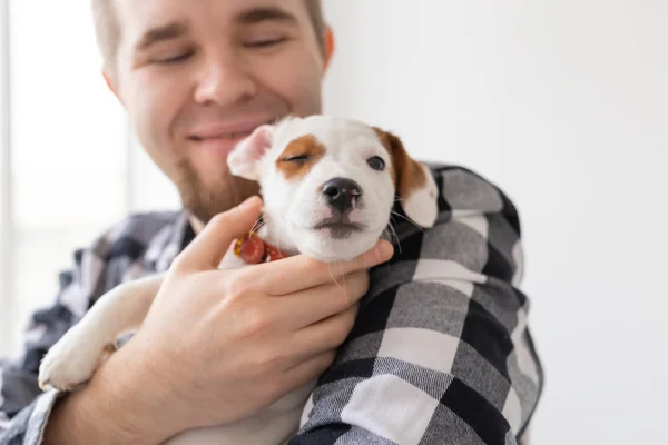 Gente, mascota y perro concepto - Primer plano retrato del hombre sosteniendo un lindo gato russell terrier cachorro — Foto de Stock