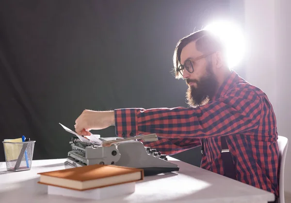 Gente, escritor y concepto hipster - joven escritor elegante que trabaja en la máquina de escribir — Foto de Stock