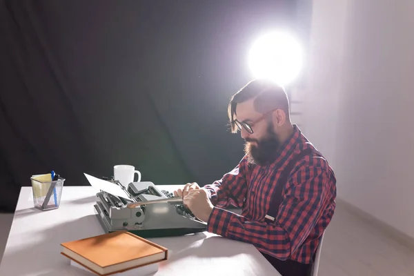 Gente, escritor y concepto hipster - joven escritor elegante que trabaja en la máquina de escribir — Foto de Stock