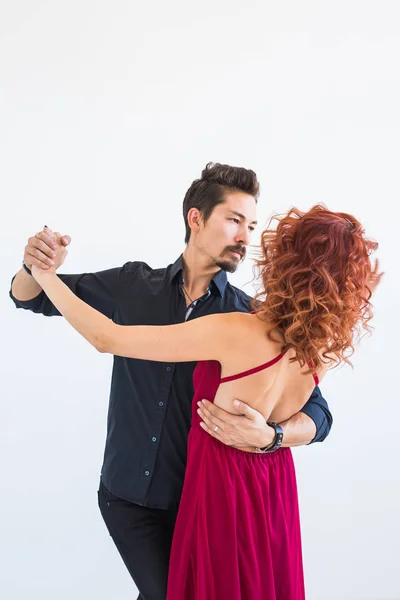 Dança social, bachata, kizomba, salsa, conceito de tango - Mulher vestida de vestido vermelho e homem em um traje preto sobre fundo branco — Fotografia de Stock