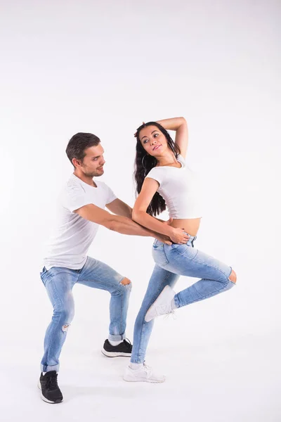 Νεαρό ζευγάρι χορό κοινωνικού χορού bachata, merengue, salsa, kizomba. Δύο κομψότητα πόζα στο λευκό δωμάτιο. — Φωτογραφία Αρχείου