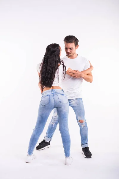 Pareja joven bailando baile social latino bachata, merengue, salsa. Dos poses de elegancia sobre fondo blanco — Foto de Stock