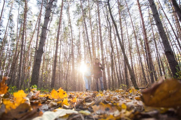 Avontuur, reizen, toerisme, wandeling en mensen concept - lachende paar lopen met rugzakken over herfst natuurlijke achtergrond — Stockfoto