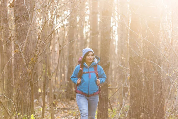 Avontuur, reizen, toerisme, wandeling en mensen concept - glimlachend toeristische vrouw lopen met rugzakken over herfst natuurlijke achtergrond — Stockfoto