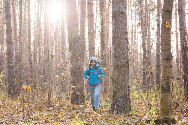 Avontuur, reizen, toerisme, wandeling en mensen concept - aantrekkelijke lachende toeristische vrouw lopen in de dikke van het bos — Stockfoto