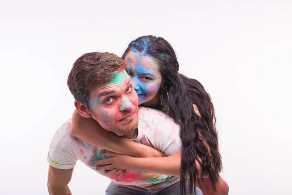 Festival de holi, amistad y concepto divertido - jóvenes jugando con colores en el festival de holi sobre fondo blanco —  Fotos de Stock