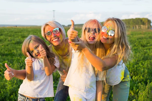Свято, фестиваль холі та концепція сім'ї Щасливі і смішні дівчата, покриті фарбою в зеленому полі жестів великі пальці вгору — стокове фото