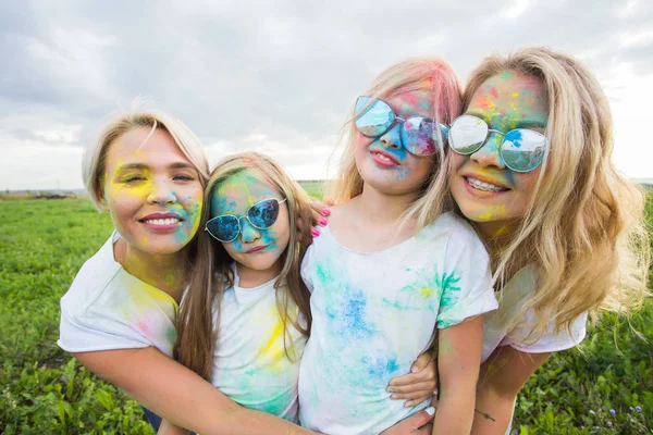 Vriendschap, feestdagen, kleur concept - vrienden lachen en plezier in de kleuren op het festival van holi — Stockfoto