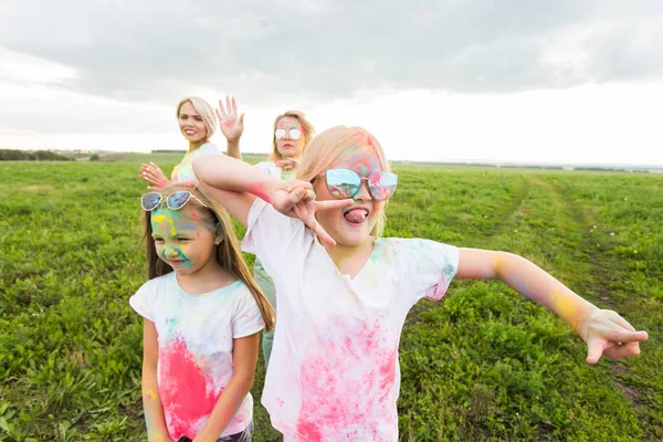 Festival de Holi, vacaciones y concepto de felicidad: los jóvenes adolescentes y las mujeres en colores se divierten al aire libre —  Fotos de Stock