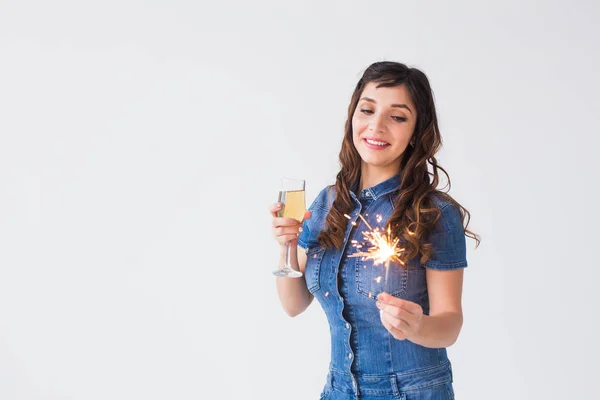 People, celebration and holiday concept - Lovely woman with sparkler and glass of champagne over white background with copy space — Stock Photo, Image