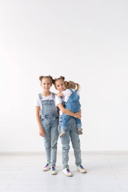 Aile ve sevgi kavramı - beyaz arka plan üzerinde sarılma üç kız kardeş