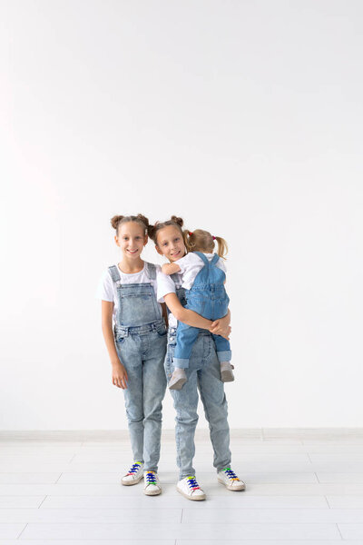 Family and love concept - Three sisters hugging over white background