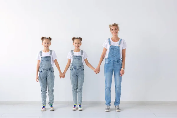 Lidé, rodina a děti koncept - dvojčata s mamčou na bílém pozadí — Stock fotografie