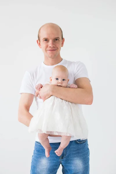 Dětství, rodina a otcovství koncept - hrdý plešatý otec drží své novorozené dítě dcera na bílém pozadí — Stock fotografie