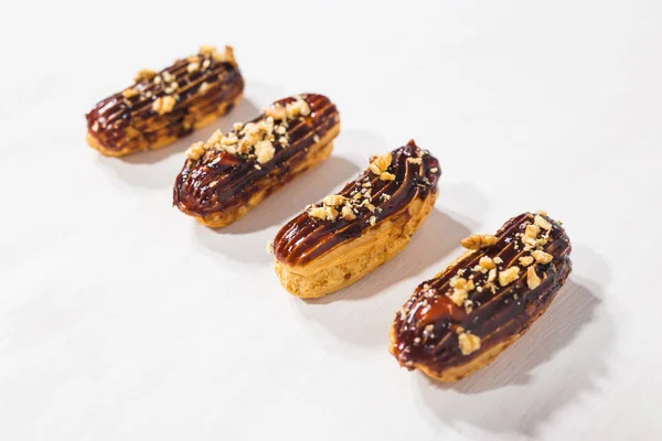 Концепция продуктов питания, десертов и хлебобулочных изделий - традиционный французский десертный эклер с шоколадом и орехами — стоковое фото