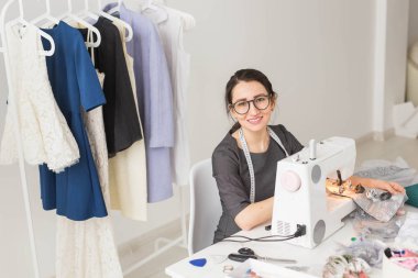 Terzi, terzi, işleri ve terzi kavramı - yüksek açı görünüm portre dikiş makinesi kullanarak gözlük gülümseyen moda tasarımcısı