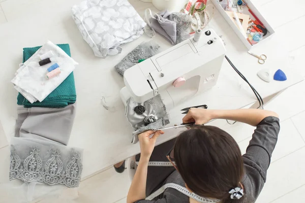 Tailor, fashion and seamstress concept - young female fashion designer in her showroom, top view — Stock Photo, Image