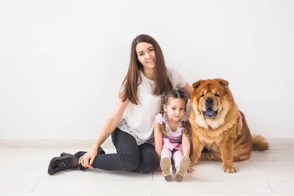 애완 동물, 아이 들 및 가족 개념-어린 소녀와 그녀의 어머니 포옹 차 개 흰색 배경 위에 — 스톡 사진