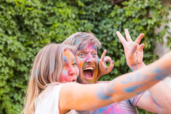 축제 holi, 사람들 개념-화려한 더러운 옷에서 젊은 부부 복용 selfie — 스톡 사진