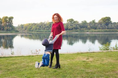 Aile, çocuk kavramı - genç anne oğlunu kucağında çember