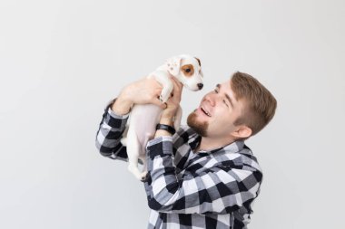 insanlar, Evcil hayvanlar ve hayvanlar kavramı - yakın yukarıya-in genç adam tutarak jack russell terrier yavru beyaz arka plan üzerinde
