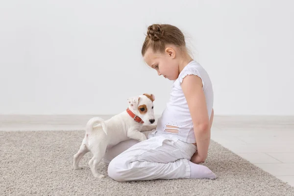 ペット、子供、動物コンセプト - 子女の子床に座って、子犬を供給 — ストック写真