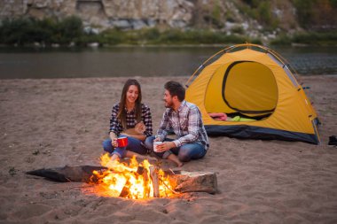Kişi, turizm ve doğa kavramı - erkek ve kadın ile onların kedi sit bir ateş yakın
