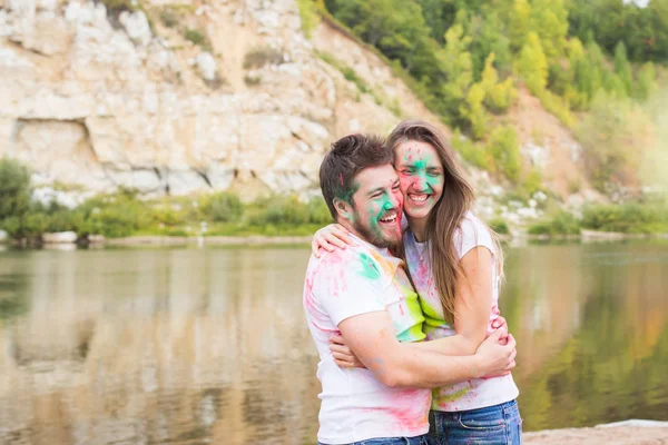 Lidé, Turistika a příroda koncept - usmívající se pár s malovanými obličeji baví — Stock fotografie