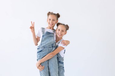 Aile ve sevgi kavramı - iki ikiz kız üzerinde sarılma gülümseyen arka plan beyaz