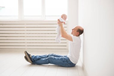 Çocuklar, Aile ve babalık kavramı - bebek kızı beyaz oda arka planda tutan mutlu kel baba