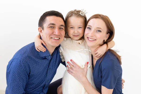 Concepto de personas, familia y felicidad - Madre y padre con hija pequeña sobre fondo blanco — Foto de Stock