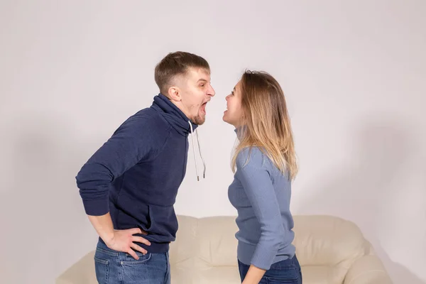 People, domestic violence and abuse concept - young couple arguing indoors — Stock Photo, Image