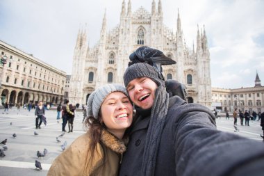 Milano Duomo Meydanı'nda güvercin ile kendi kendine portre çekici çift. Kış seyahat, İtalya ve ilişki kavramı