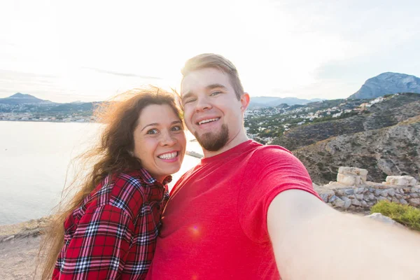 Viagens, férias e férias conceito - casal feliz tomando selfie sobre bela paisagem — Fotografia de Stock