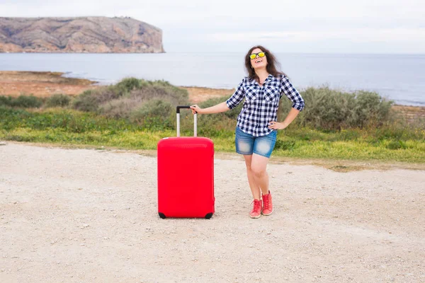 Viaggio, turismo e persone concetto - ragazza felice in piedi con valigia rossa — Foto Stock