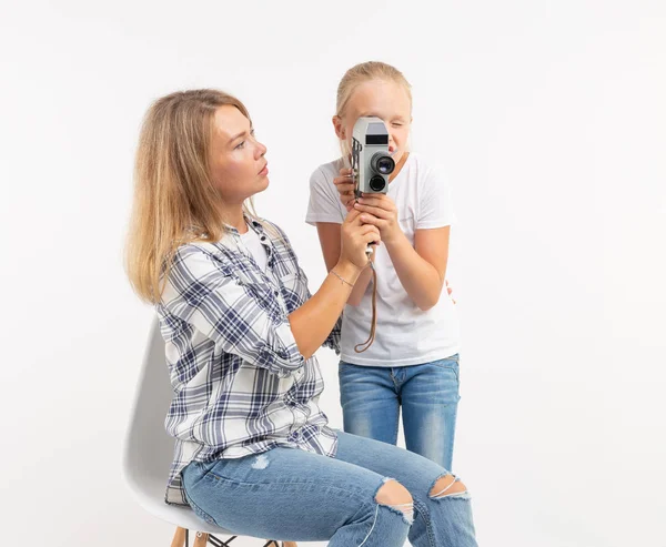 Familia, fotografía y concepto de hobby - mujer y su hijo usando una cámara antigua sobre fondo blanco — Foto de Stock