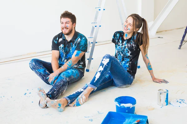 Rénovation, redécoration et concept de personnes - jeune couple faisant une rénovation dans une maison neuve et amusez-vous à la pause — Photo