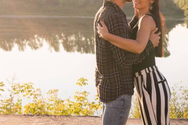 İnsanlar, aşk ve doğa kavramı-doğa arka planda ayakta iken birbirlerine kucaklayan genç güzel çiftin yakın