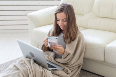 Çalışma, rahat, insanlar kavramı - ekose evde çalışma, çay içme ve netbook chat yapan genç kadın