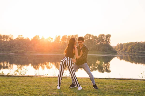 Ρομαντικό, κοινωνική χορό, άνθρωποι έννοια - νεαρό ζευγάρι που χορεύει bachata κοντά στη λίμνη σε ηλιόλουστη μέρα — Φωτογραφία Αρχείου
