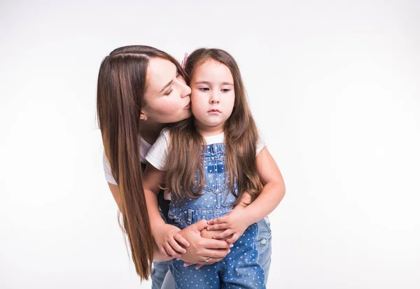 Conceito de maternidade, família e relacionamento - Mãe feliz e filha pequena se divertindo no fundo branco — Fotografia de Stock