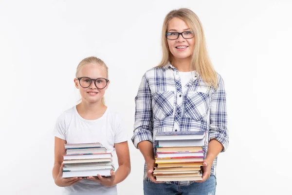 Wissen, Lesen und Bildungskonzept - Mutter und Tochter mit Büchern auf weißem Hintergrund. — Stockfoto